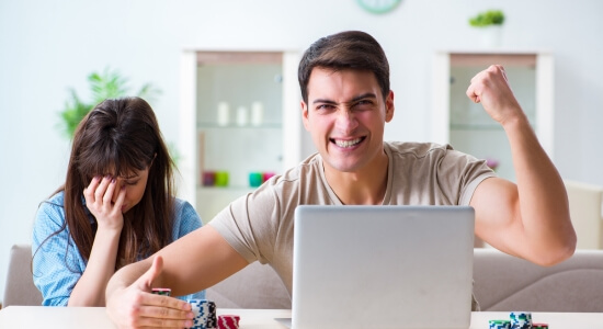 Homme et femme avec des jetons de casino et un ordinateur portable